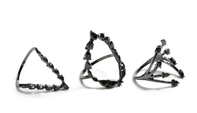 Three black metallic rings with gem clusters on white, sleek jewelry display